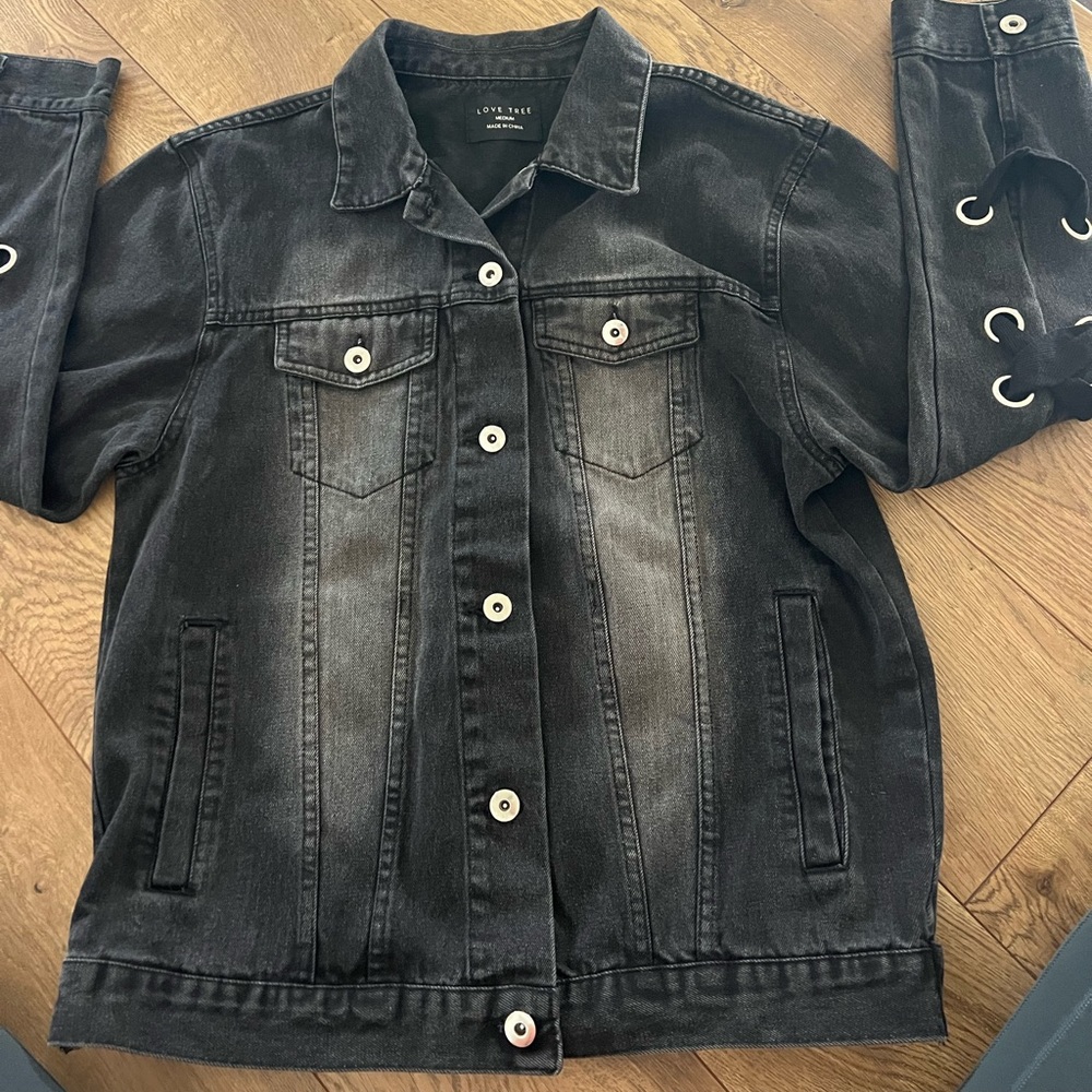 Black denim jacket with lace up feature along arms and back